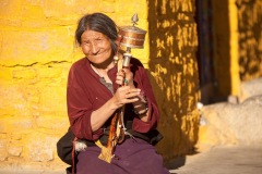 Tibetan woman with prayer wheel in traditional clothing